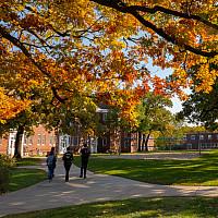 Students walk together to class under the colorful leaves of Beloit's campus in autumn.