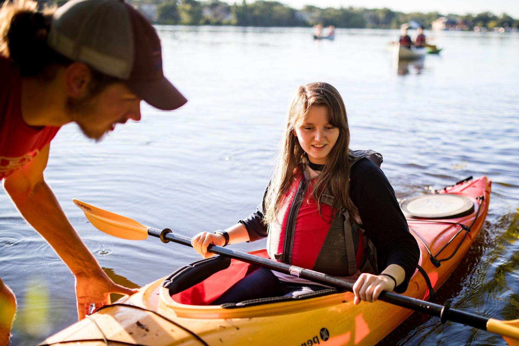 Students prepare to launch a kayak during a Buccaneer Boathouse event on the Rock River.